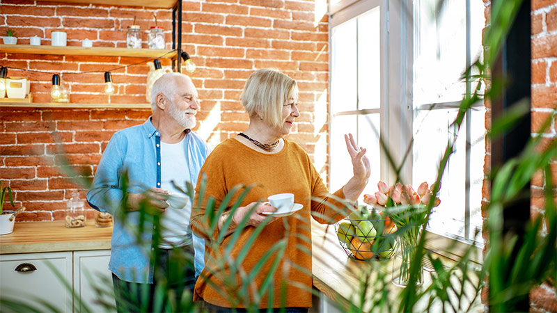 senior couple drinking coffee in kitchen with exposed brick walls what are the benefits of an annuity portsmouth nh